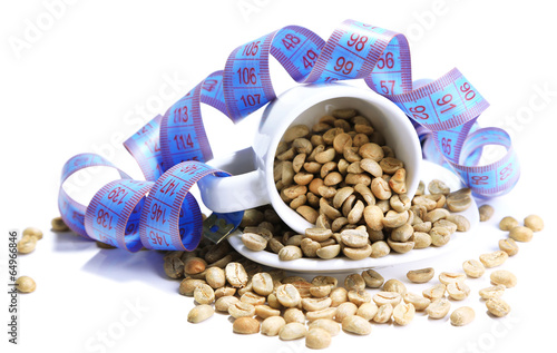 Raw green coffee beans in cup and measuring tape, isolated