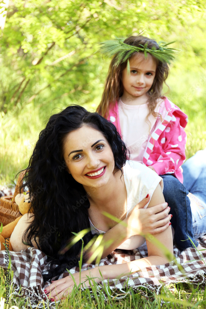 Fototapeta premium Happy mom and daughter. Picnic in the green park