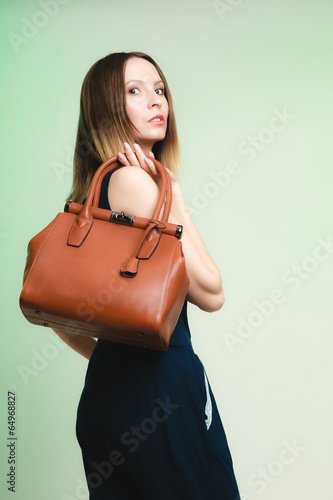Elegant outfit. Stylish woman with brown bag
