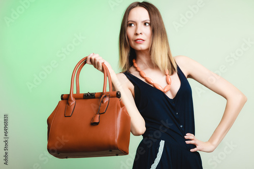Elegant outfit. Stylish woman with brown bag