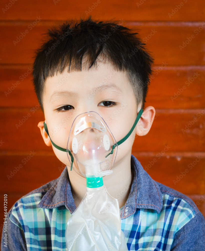 Asian boy wearing oxygen mask.
