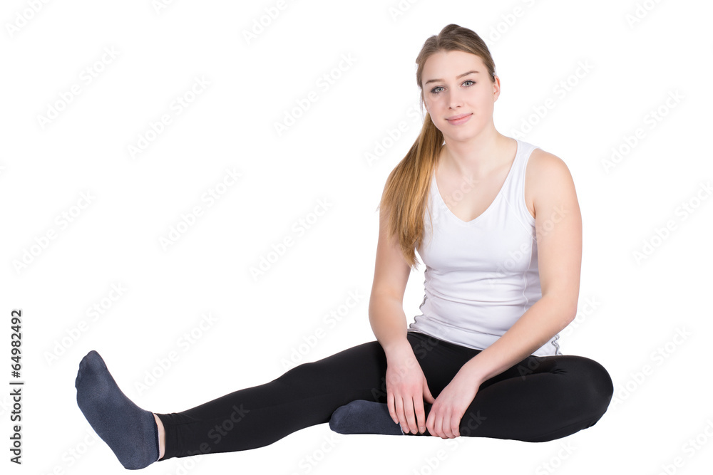 Fototapeta premium Junge Sportlerin sitzt entspannt auf dem Boden