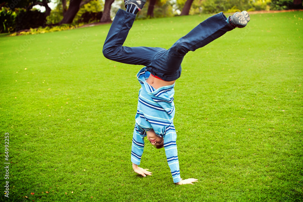 Beautiful child playing on green grass in sunny park jumping Beautiful child playing on green grass in sunny park jumping