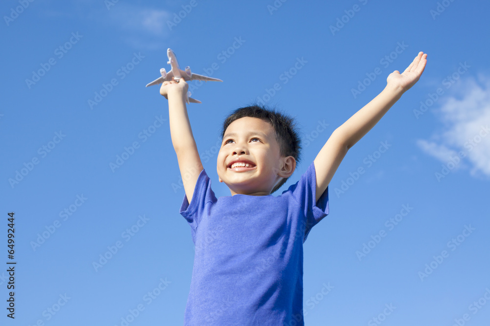 joyful little boy holding a toy with blue sky background joyful little boy holding a toy with blue sky background