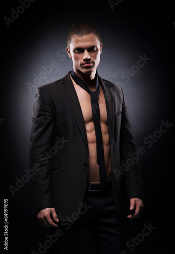 Strong, fit and sporty stripper man over black background