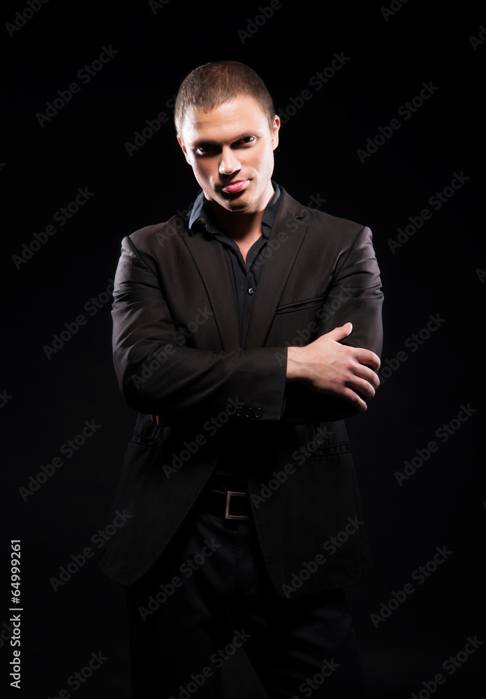 Strong and handsome man in suit over dark background Strong and handsome man in suit over dark background