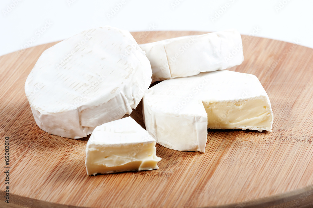 a few pieces of cheese on a wooden board