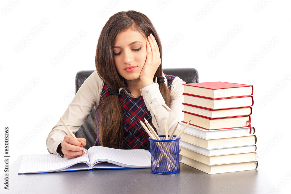 Portrait of bored schoolgirl doing his homework at desk Portrait of bored schoolgirl doing his homework at desk