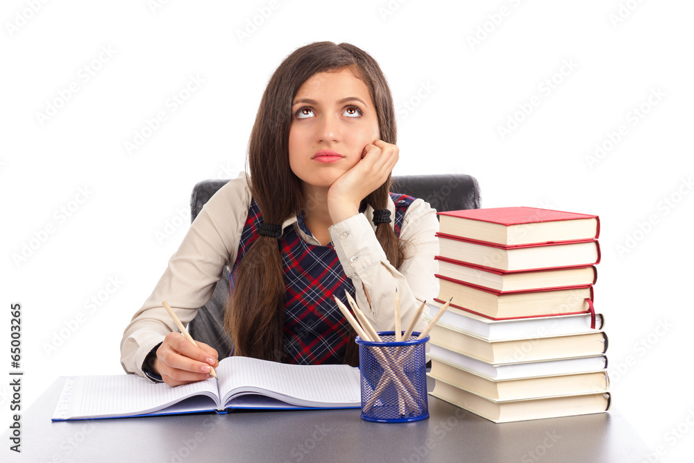 Portrait of bored schoolgirl doing his homework at desk Portrait of bored schoolgirl doing his homework at desk
