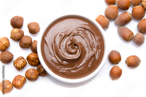 A cup of chocolate hazelnut spread with hazelnuts