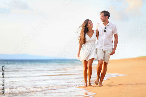 Beach couple walking on romantic travel photo