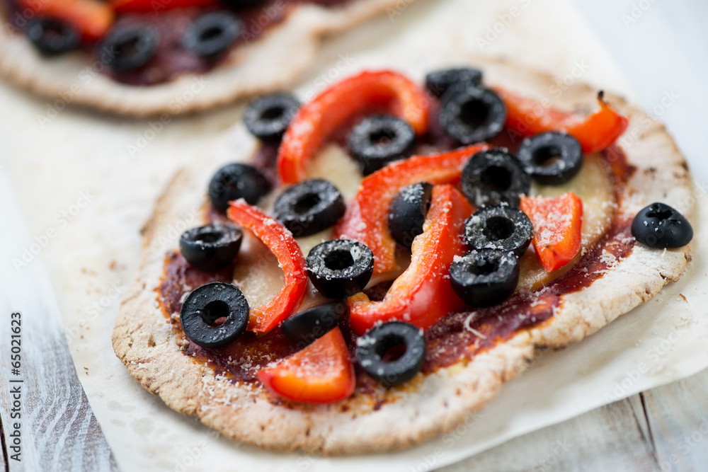 Mini pizzas with olives and red bell pepper slices, studio shot Mini pizzas with olives and red bell pepper slices, studio shot
