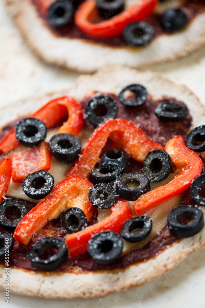 Vegetarian mini pizzas with olives and red bell pepper, close-up Vegetarian mini pizzas with olives and red bell pepper, close-up