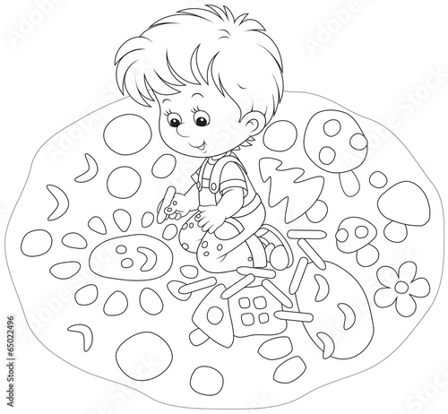 Little boy drawing a picture with chalk on asphalt
