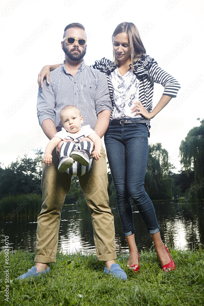 Family posing in park by lake