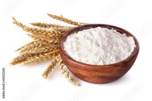 flour with wheat in a wooden bowl on a white background