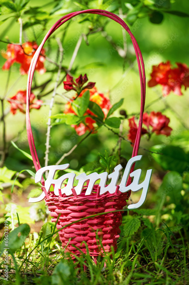 Family decoration word and wicker basket in the garden