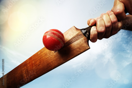 Cricket player hitting ball photo