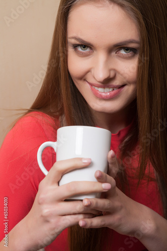 closeup of woman holding white cup.