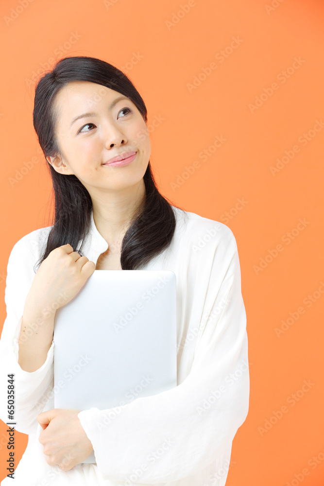 ノートパソコンを持つ若い女性