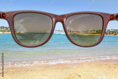Fototapeta Naklejka Na Ścianę i Meble -  The view through the sunglasses beautiful beach and sea