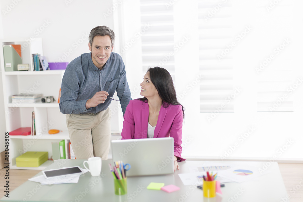 Obraz premium two colleagues talking about a project in front a computer