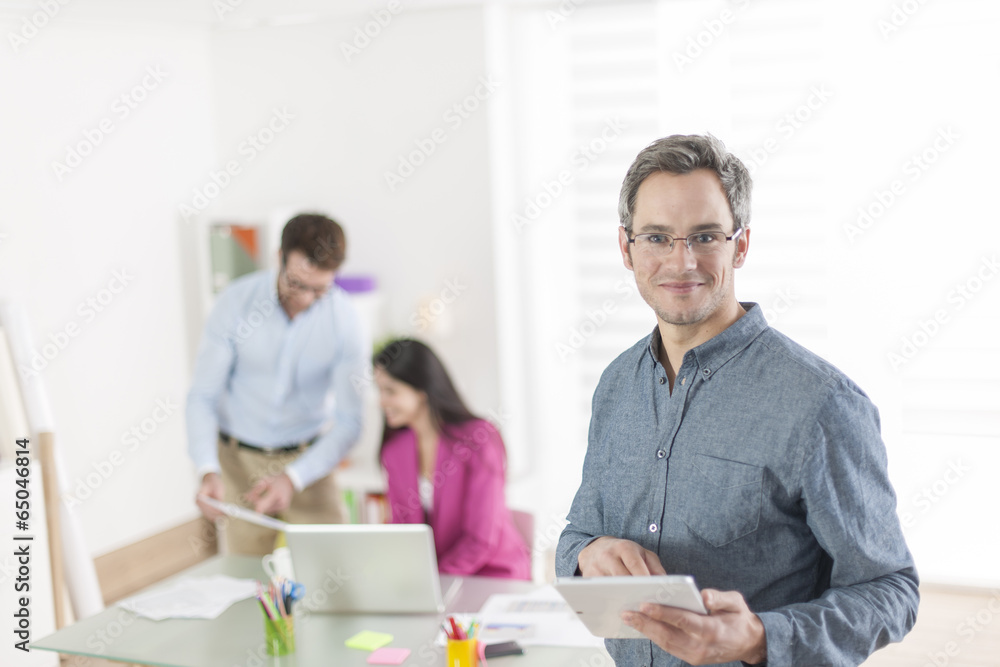businessman using a digital tablet and standing in front of his businessman using a digital tablet and standing in front of his