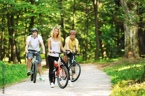 Group of attractive happy people on bicycles in the countryside