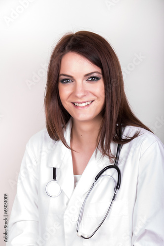 Young beautiful brunette female doctor on the white background
