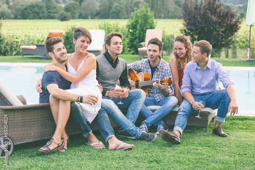 Group of Friend Singing Together next to Swimming Pool