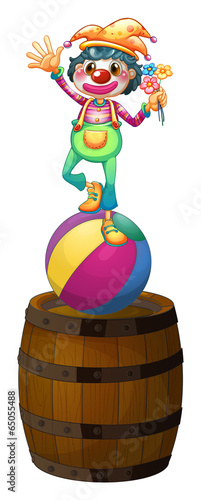 A playful clown above the wooden barrel