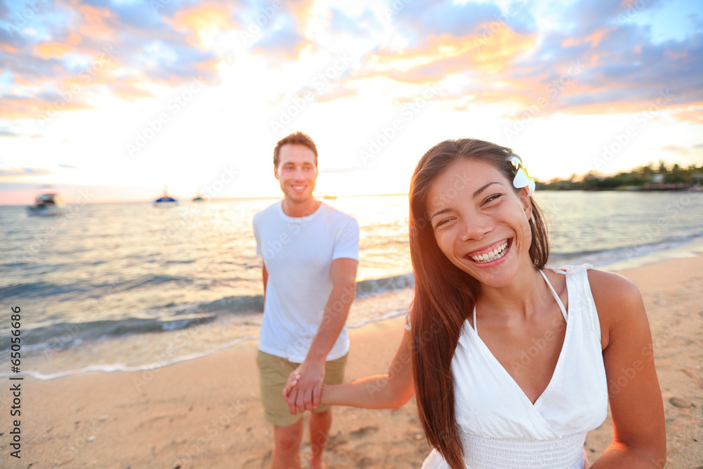 Happy couple on beach holding hands at sunset Happy couple on beach holding hands at sunset
