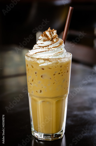Iced coffee with whipped cream on the table.