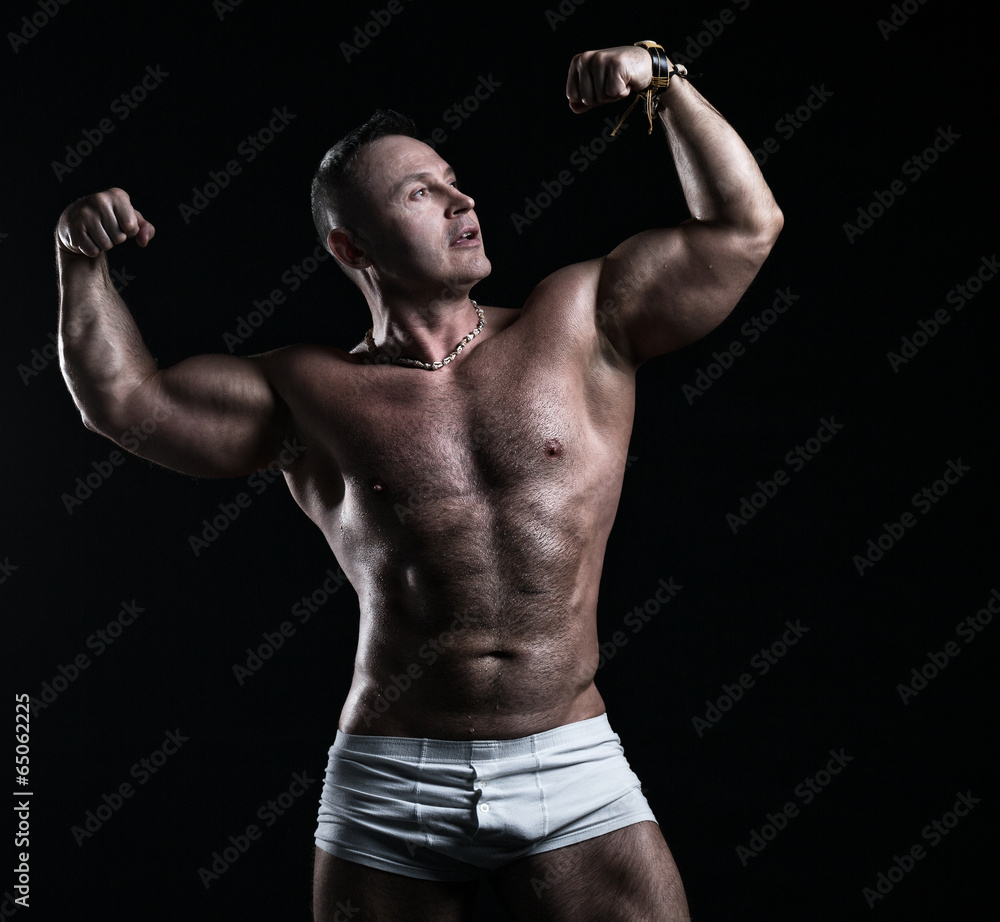 Bodybuilder in studio on a black background