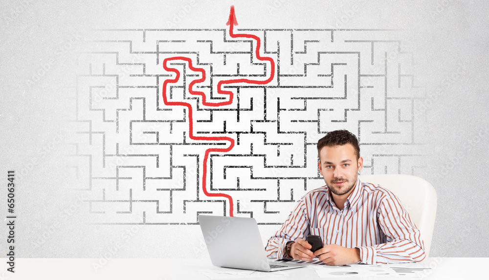 Business man at desk with labyrinth and arrow Business man at desk with labyrinth and arrow