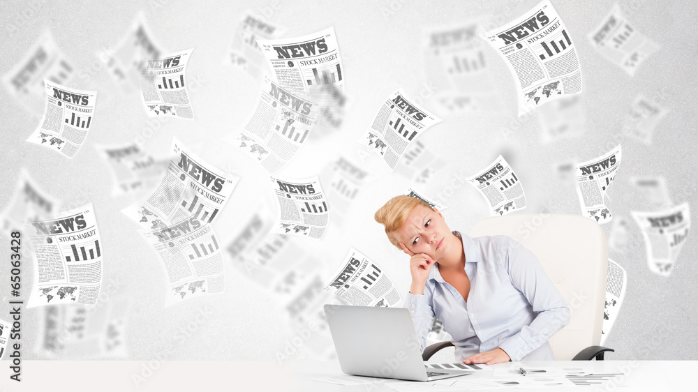 Business woman at desk with stock market newspapers Business woman at desk with stock market newspapers