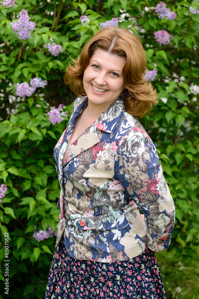 Middle-aged woman near blossoming lilac Middle-aged woman near blossoming lilac