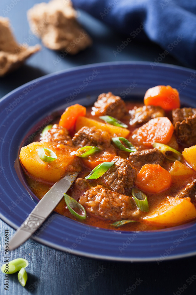 beef stew with potato and carrot in blue plate beef stew with potato and carrot in blue plate