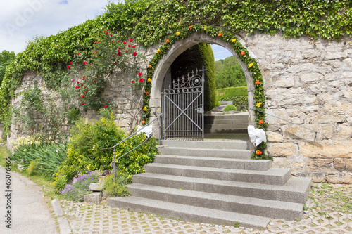 Mit Blumen geschmückter Friedhofseingang photo