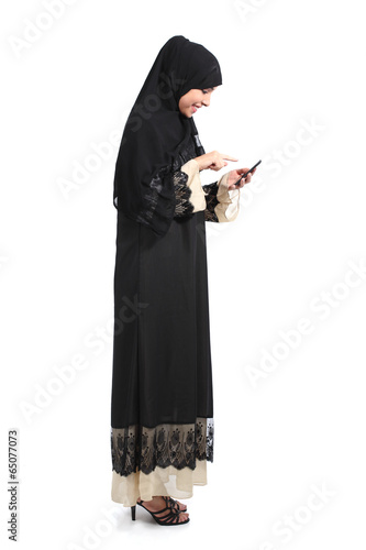 Full body of an arab saudi woman browsing a smart phone
