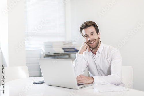 handsome businessman at office in front his laptop