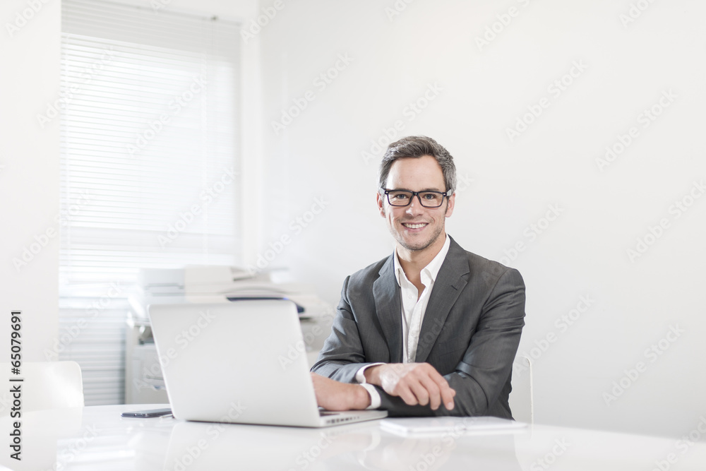 handsome businessman at office in front his laptop handsome businessman at office in front his laptop