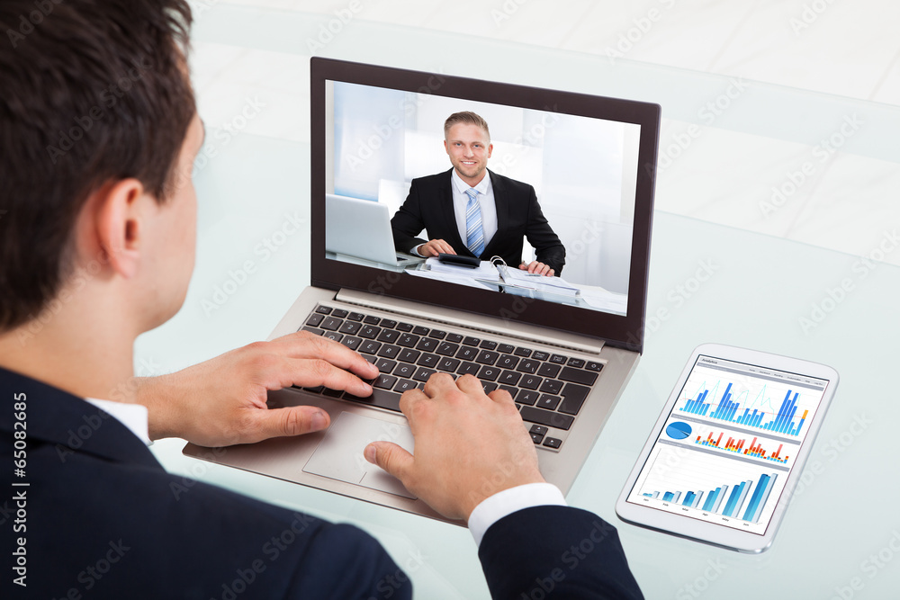 Businessman Video Conferencing On Laptop In Office Businessman Video Conferencing On Laptop In Office