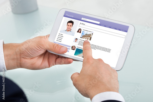 Businessman Using Social Networking Site On Digital Tablet