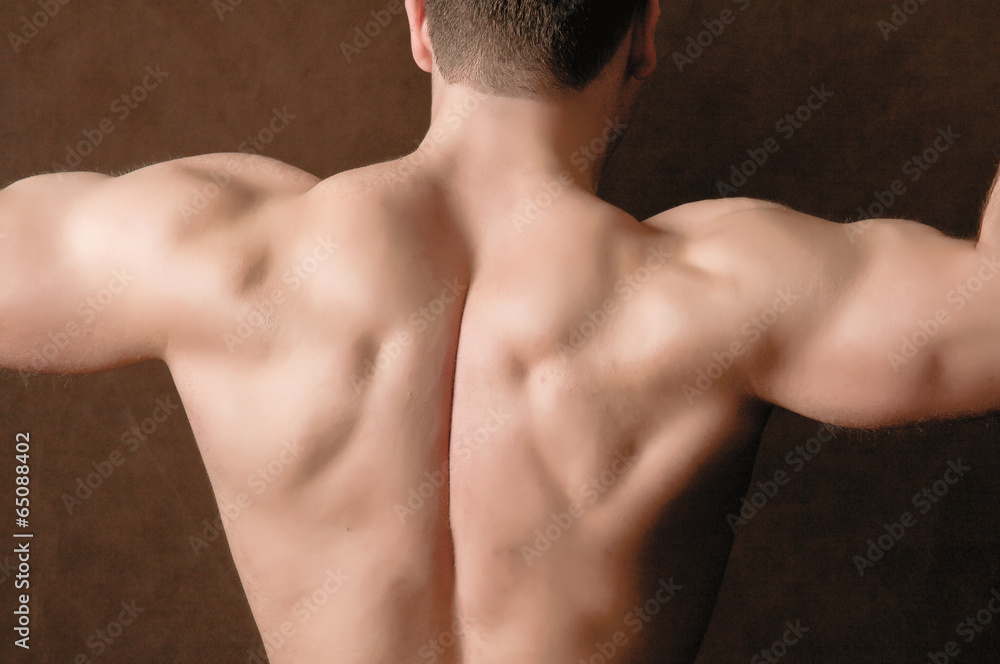 Portrait of a naked muscular man, isolated on brown background Portrait of a naked muscular man, isolated on brown background