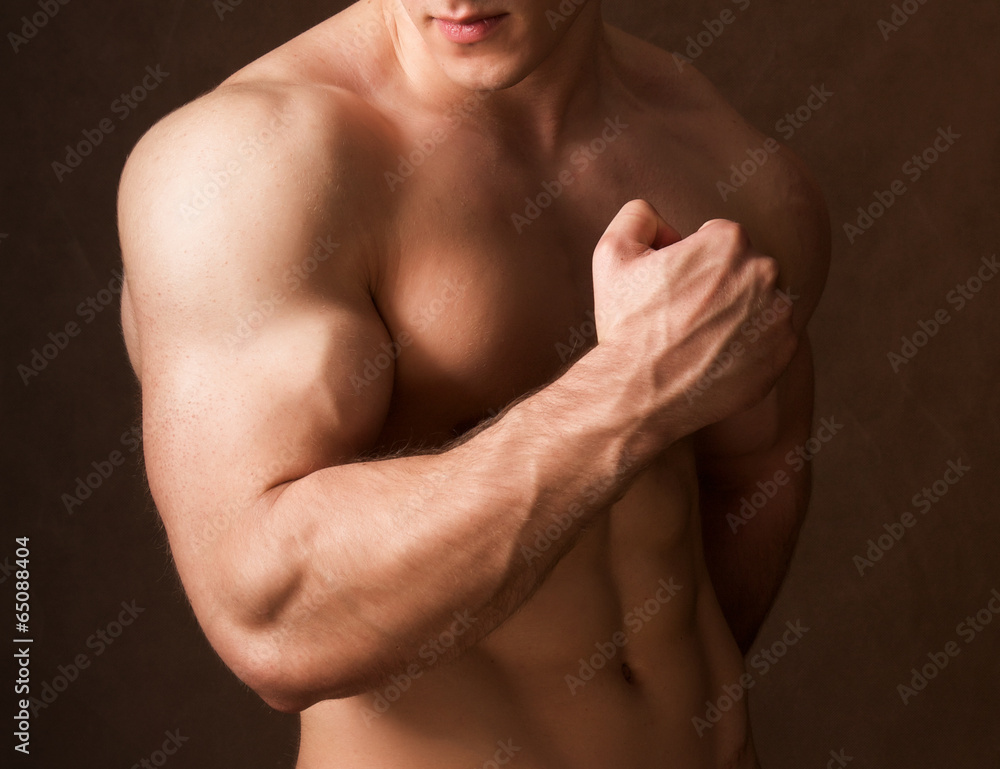 Portrait of a naked muscular man, isolated on brown background Portrait of a naked muscular man, isolated on brown background