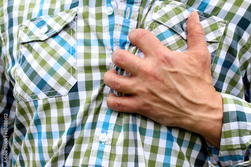 Mann hat Herzinfarkt fasst sich verkrampft an Brust