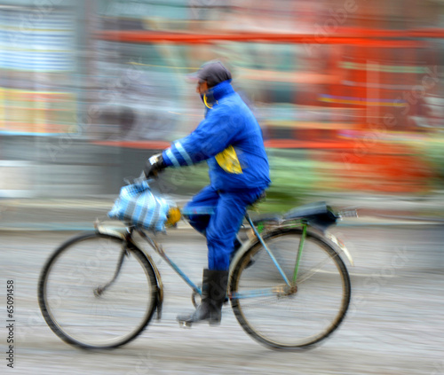 Cyclist in motion riding down the street