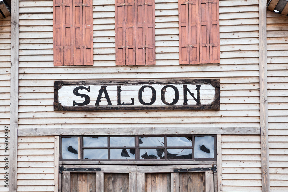 Saloon iscription on wooden building facade Saloon iscription on wooden building facade