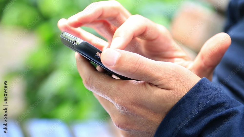 Man Using a Smartphone in park Man Using a Smartphone in park